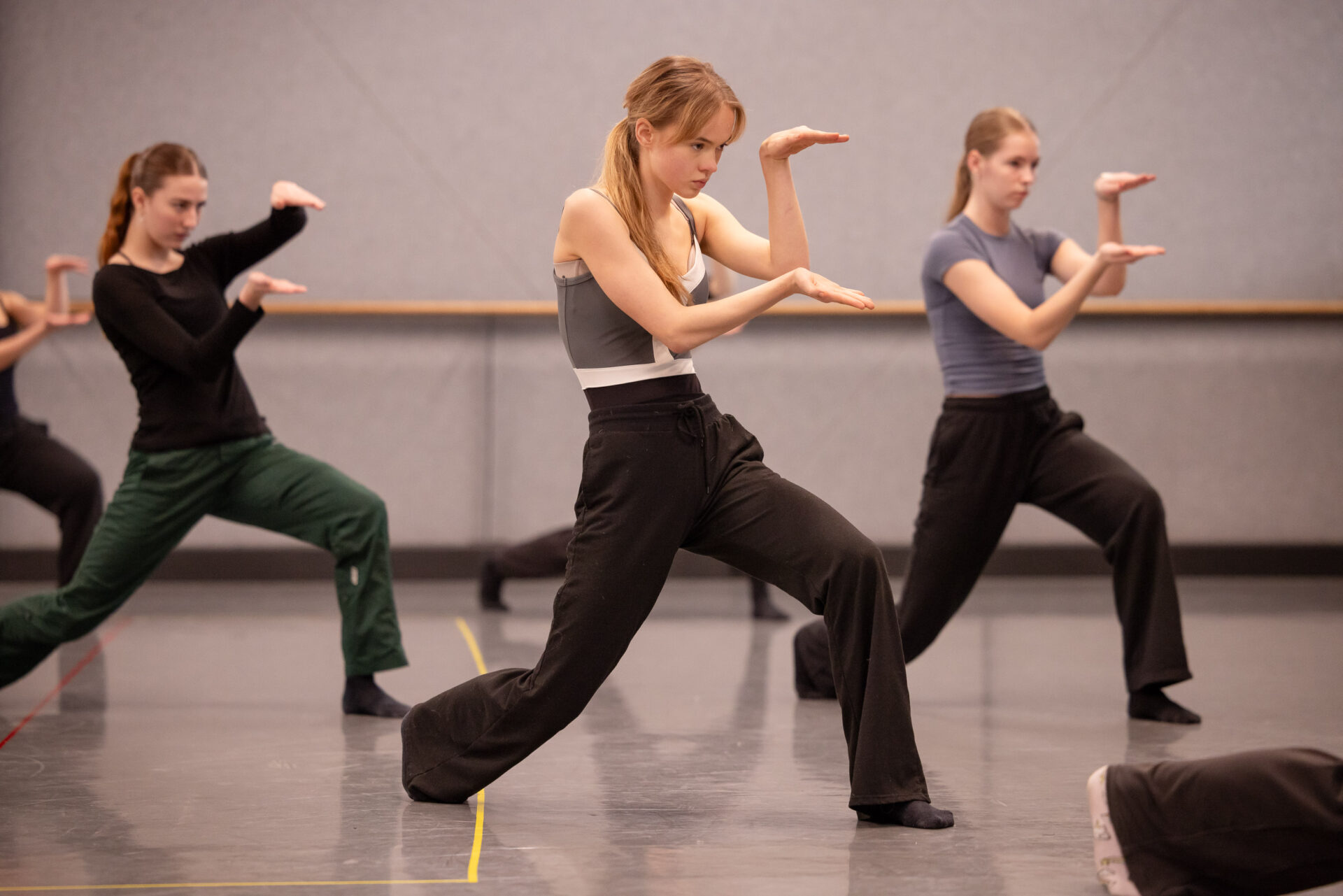Three Senior Youth Ensemble members dancing in the studio at Sydney Dance Company.